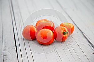 five red tomatoes on the gray table