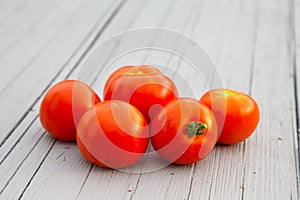 Five red tomatoes on the gray table