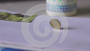 A five-rupee coin spinning on the table. coin turn or spin on the table