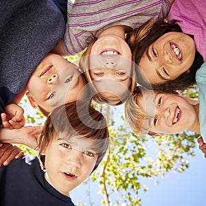 Five schoolchildren standing in a circle and smiling