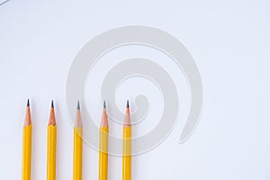 Five Sharpened Pencil Tips Pointing Up on White Background