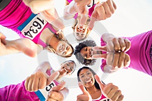 Five smiling runners supporting breast cancer marathon