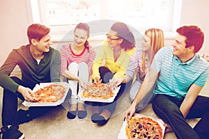 Five smiling teenagers eating pizza at home