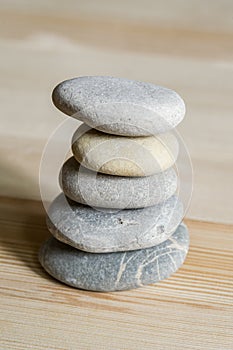 Five spa zen stones stacked on a wood background