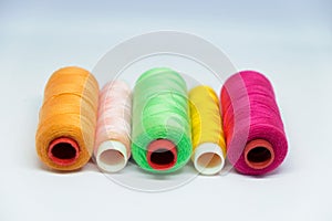 Five spools of colorful sewing thread.