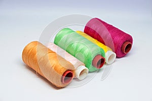 Five spools of colorful sewing thread.