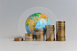 Five stacks of coins with a globe