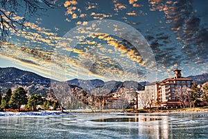 The Five Star Broadmoor Hotel in Colorado Springs with frozen pond, ice, mountains and clouds