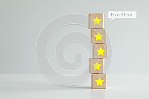 Five star on stack of wooden block with Excellent on speech bubble. Evaluation, Satisfaction, Feedback, Review concept.