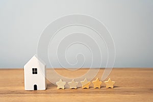 Five stars and a wooden house on a gray background photo