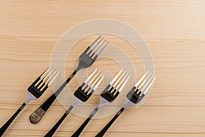 Five steel forks on wooden background