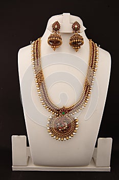 five strands necklace with red green white stones and white and golden beads with matching earring jhumki.