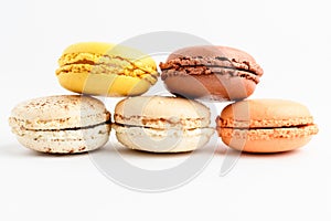 Five sweet French macarons with flavours of lemon, caramel, vanilla, coconut and chocolate, pastel colors of sweets isolated on wh