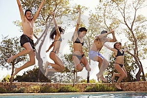 Five teenagers jumping into an outdoor swimming pool, Ibiza