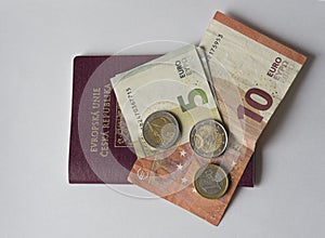 Five and ten euros bank bill and two and one euro coin on EU pas