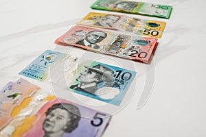 Five ten twenty fifty hundred Australian dollar banknotes on the white background