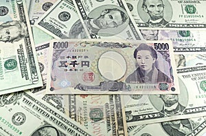 Five thousand Japanese yen notes on many dollars background