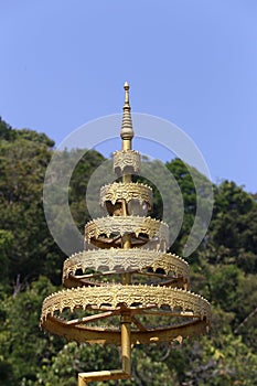Five tiered gold symbol on mountains and sky background