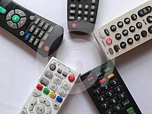 Five tv remotes on a white background