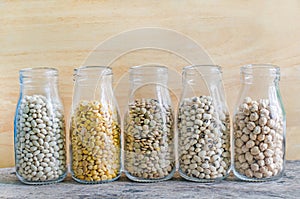 Five types of cereal and grain seeds in glass bottle consisted of white bean, soybean, lentil, black eye pea and chick pea