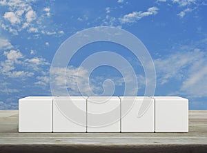 Five white block cubes on wooden table