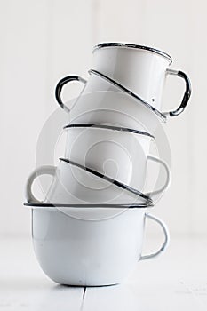 Five white enameled mugs