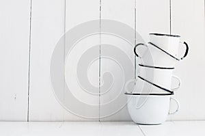 Five white enameled mugs