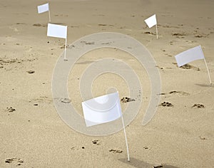Five white flags at the beach