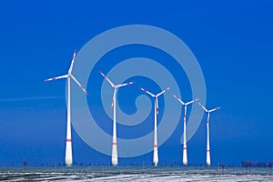 Five windmills ia a row in winter landscape