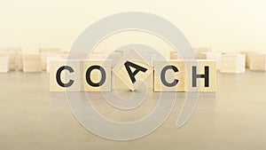 five wooden blocks with the letters COACH on the surface table