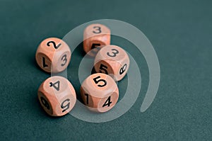 Five wooden dice with different numbers on white background.