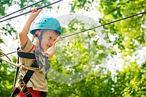 Five year boy on rope-way in forest