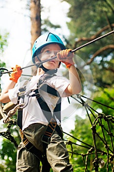 Five year boy on rope-way in forest