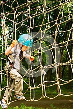 Five year boy on rope-way in forest