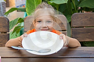 Five-year girl showing empty plate to eat