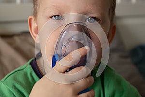 five-year-old boy breathes a black nebulizer. close up