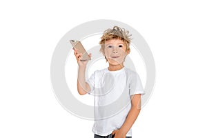 Five year old boy stands with a phone in his hand