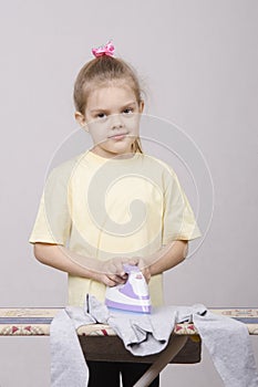 Five year old girl ironing 