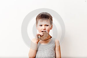 Five-year Russian boy in a gray t-shirt bites buttery pancake