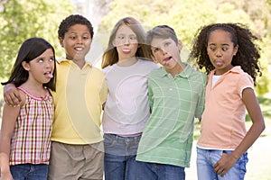 Five young friends outdoors making funny faces photo