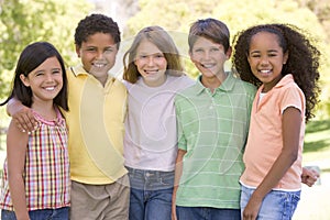 Five young friends standing outdoors smiling