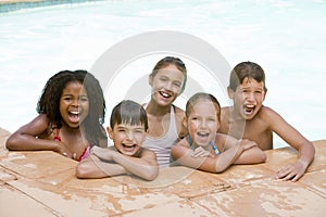 Five young friends in swimming pool smiling