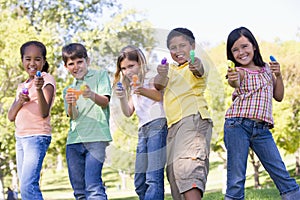 Five young friends with water guns outdoors