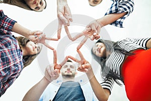 Five young smiling people make star shape from fingers