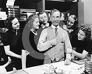 Five young women gathering around a salesman in a store