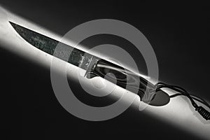 Fixed blade tactical knife with sheath on white background in hard light