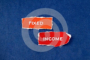 Fixed income words written on torn paper pieces with blue background