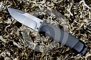 Fixed knife on dry grass. Diagonal position. Cold teperature.