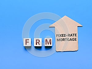 Fixed Rate Mortgage or FRM on wooden cubes with house cupboard.