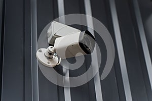 Fixed security camera attached to profiled steel siding with rigid mounting arm